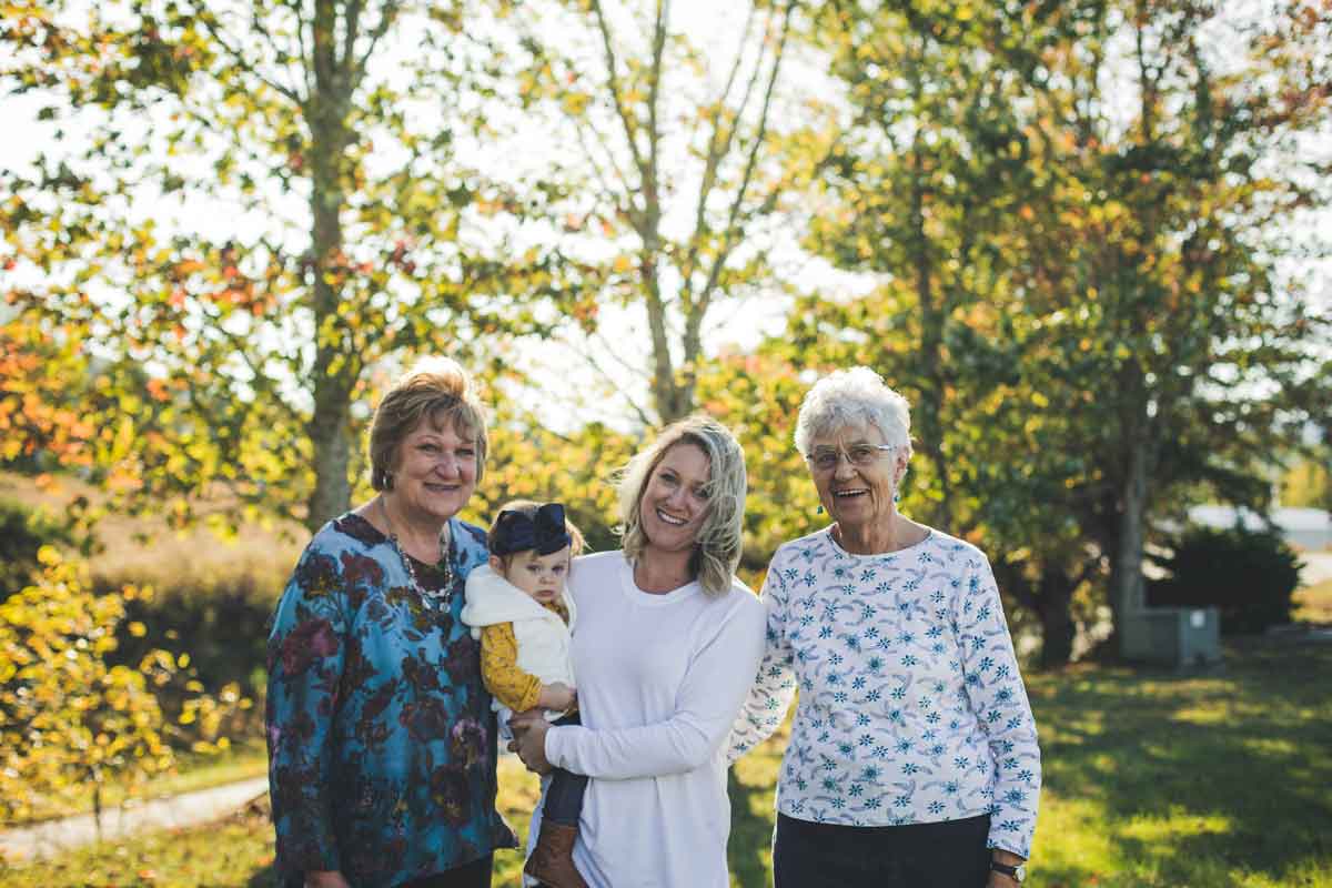 Debra Hedden with her mother, daughter and granddaughter standing outside in the sun, Franklin, NC. Mountain BizWorks