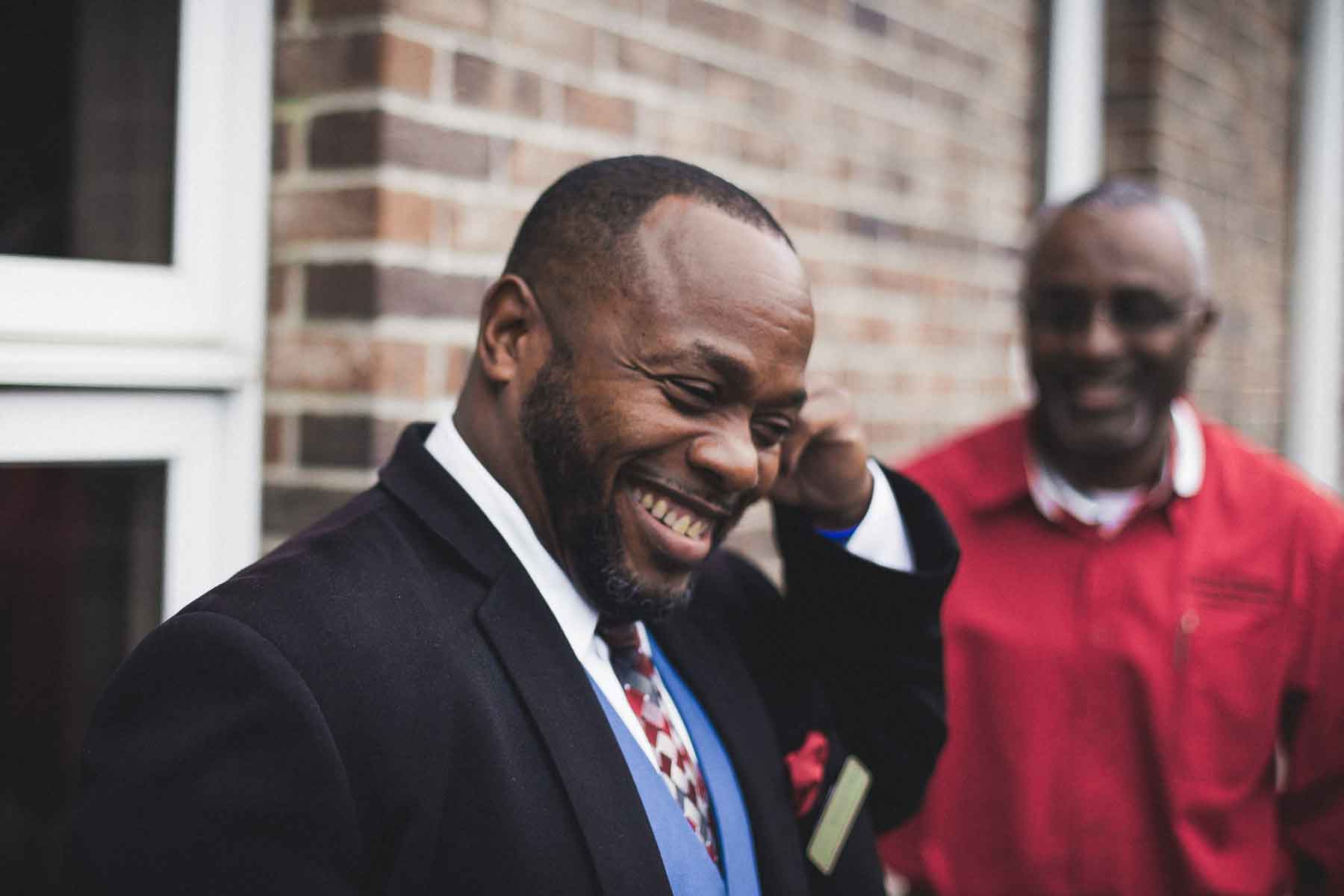 Nian Avery of Avery's Memorial Chapel smiling as he talks to coworkers. Mountain BizWorks