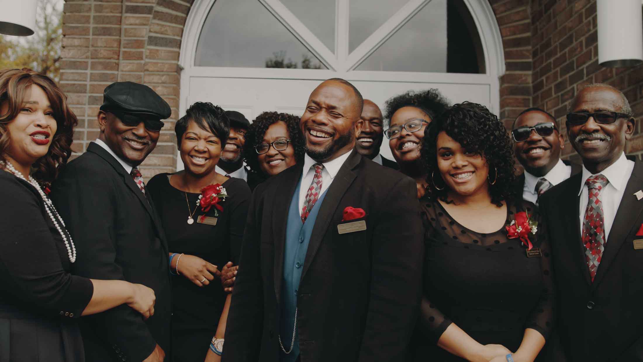 The team of Avery's Memorial Chapel standing and smiling on the front steps of the chapel.