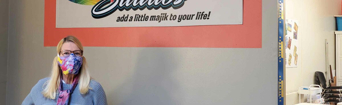 Pam Granger stands in front of her studio sign, Majik Studios, Asheville, NC.